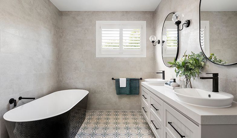 A bathroom with two sinks , a bathtub and a mirror.