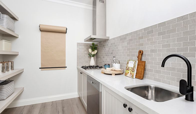 A kitchen with a sink , stove , and dishwasher.