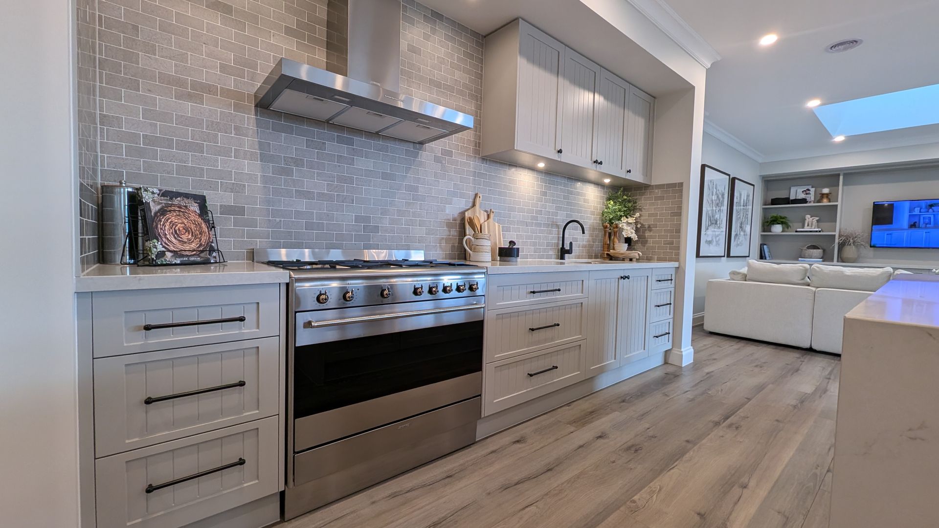 A kitchen with stainless steel appliances and white cabinets.