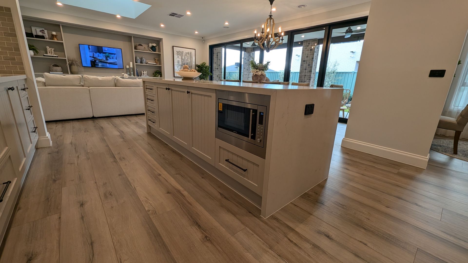A kitchen with a large white island in the middle of the room.