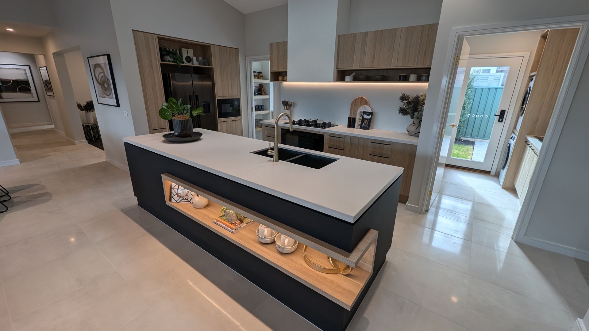 A kitchen with a large white and black island in the middle of it.