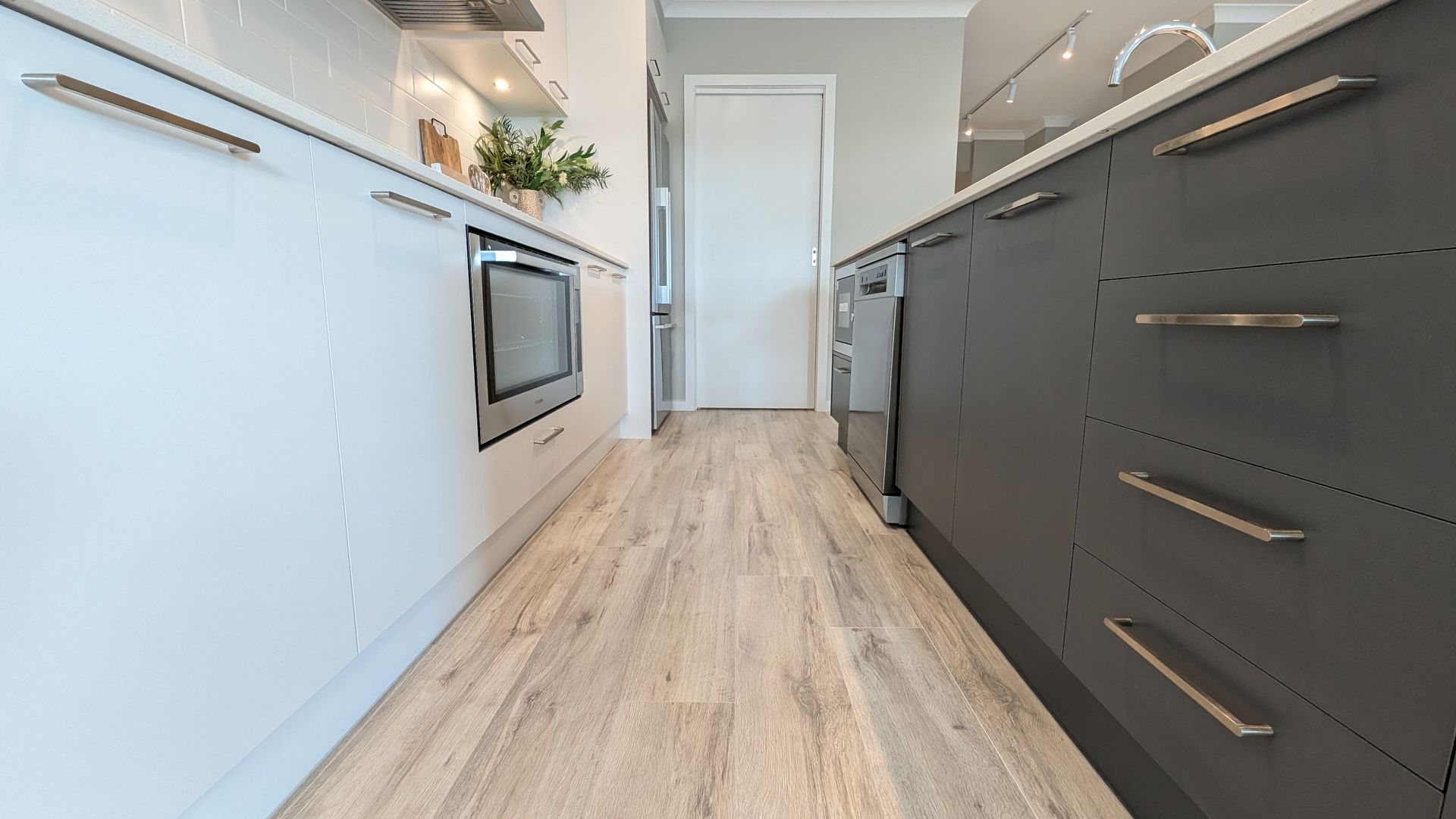 A kitchen with a wooden floor and white cabinets