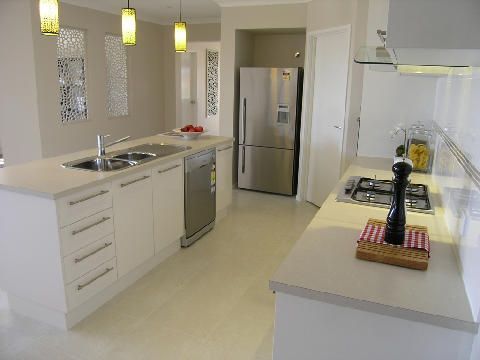 A kitchen with white cabinets and a stainless steel refrigerator