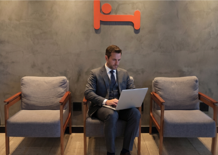 Executivo trabalhando com notebook em ambiente do Hus Hotel Maringá.
