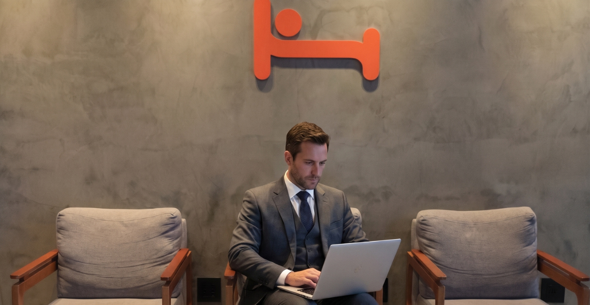 Executivo trabalhando com notebook no lobby do Hus Hotel Maringá.