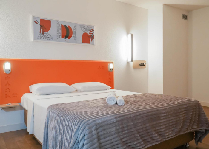 Apartamento do Hus Hotel Maringá com estação de trabalho para viajantes corporativos.
