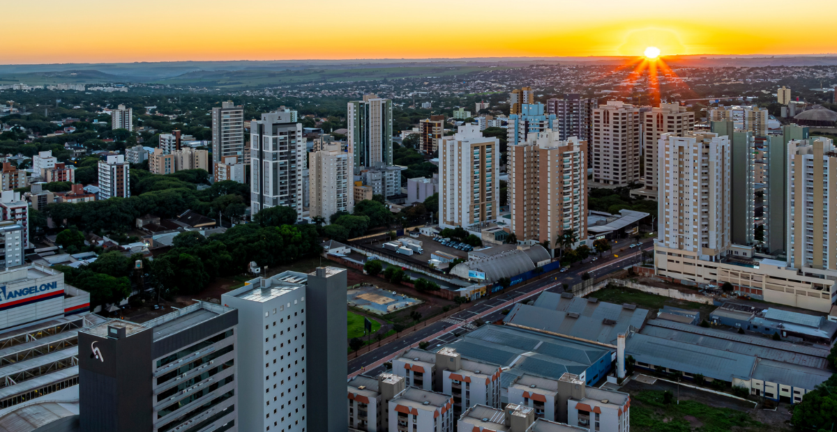 Vista aérea com por do sol em meio ao horizonte em Maringá