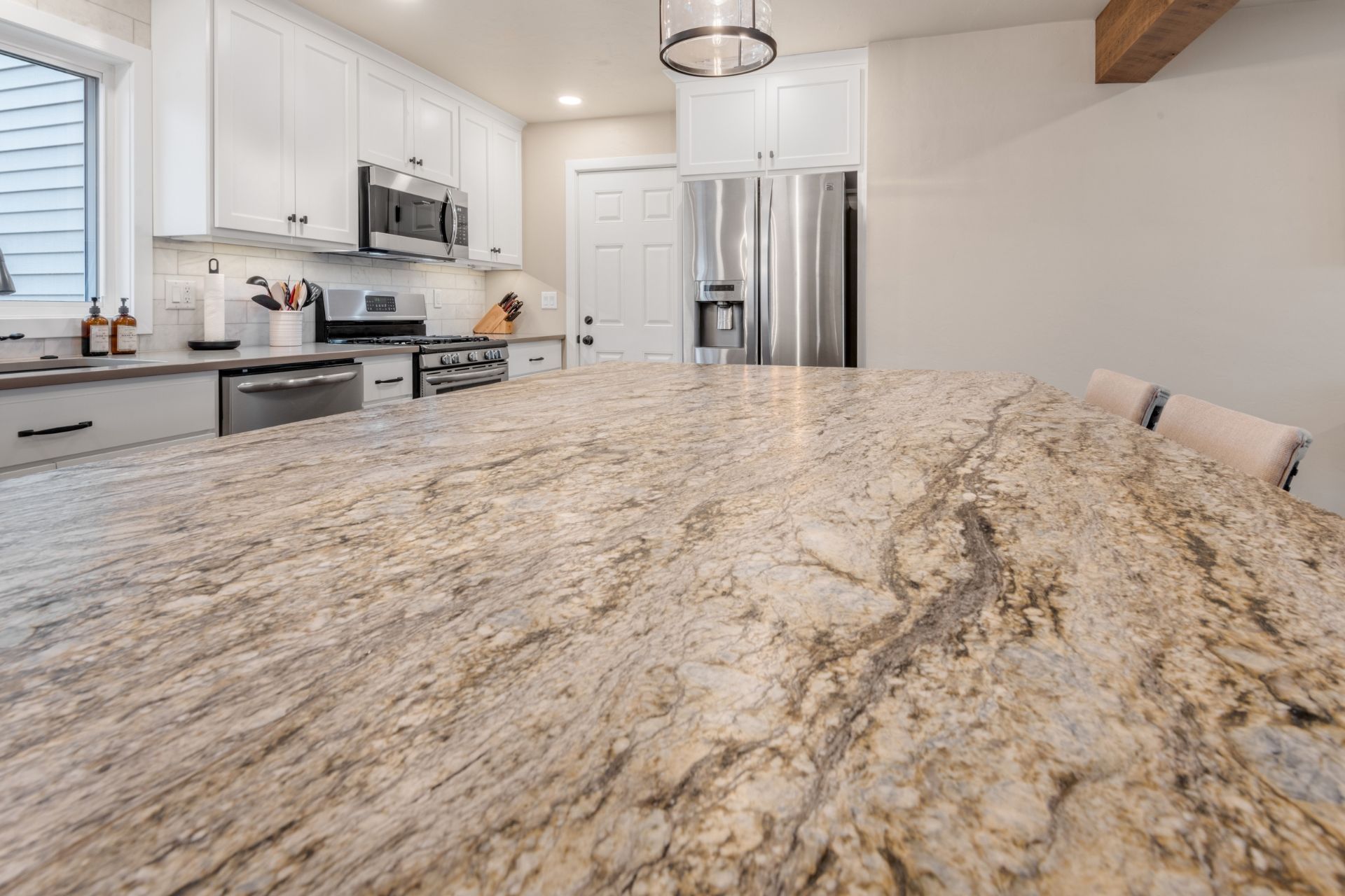 A kitchen with granite counter tops and stainless steel appliances.