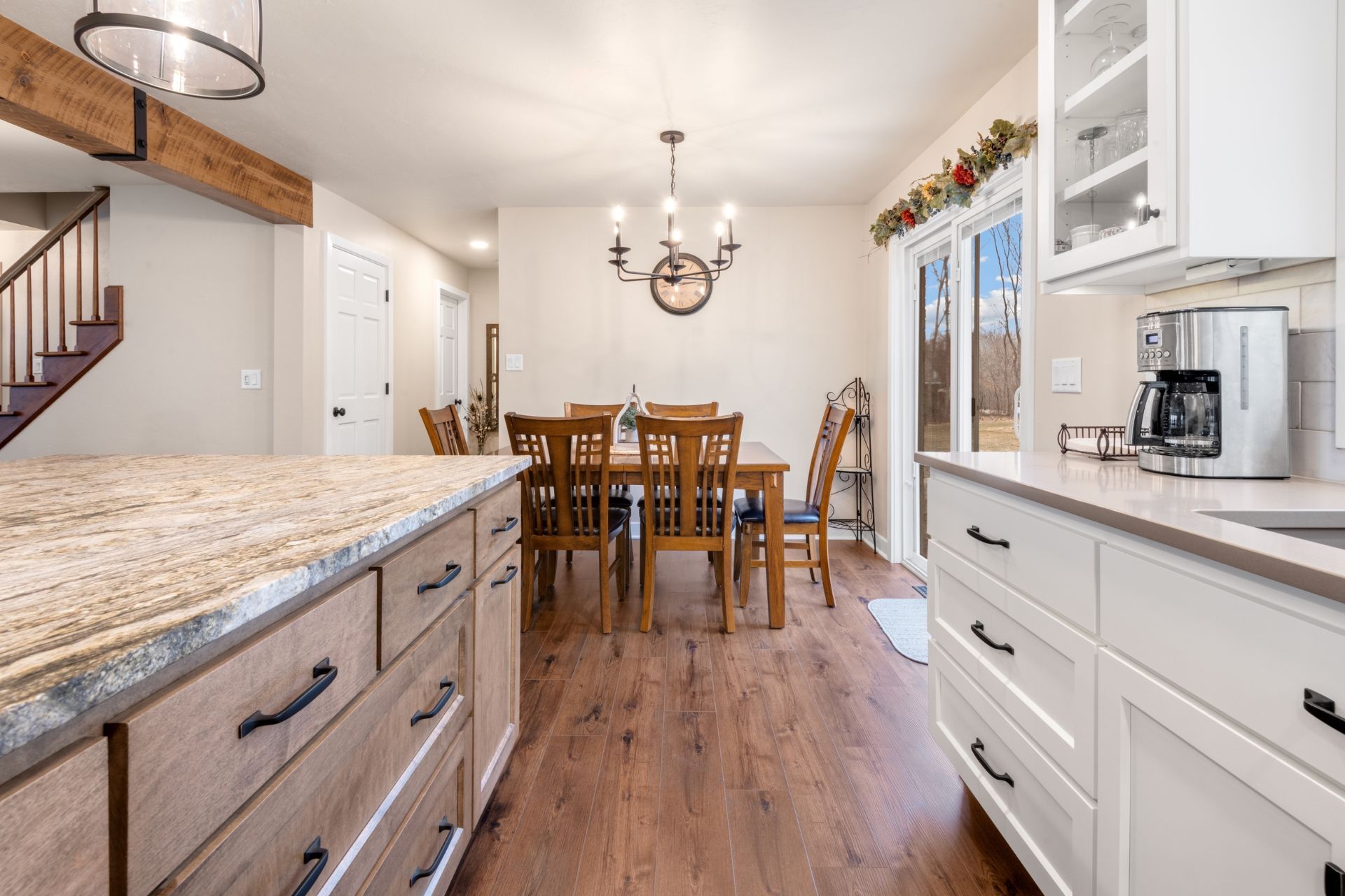 A kitchen with a dining room table and chairs in the background.