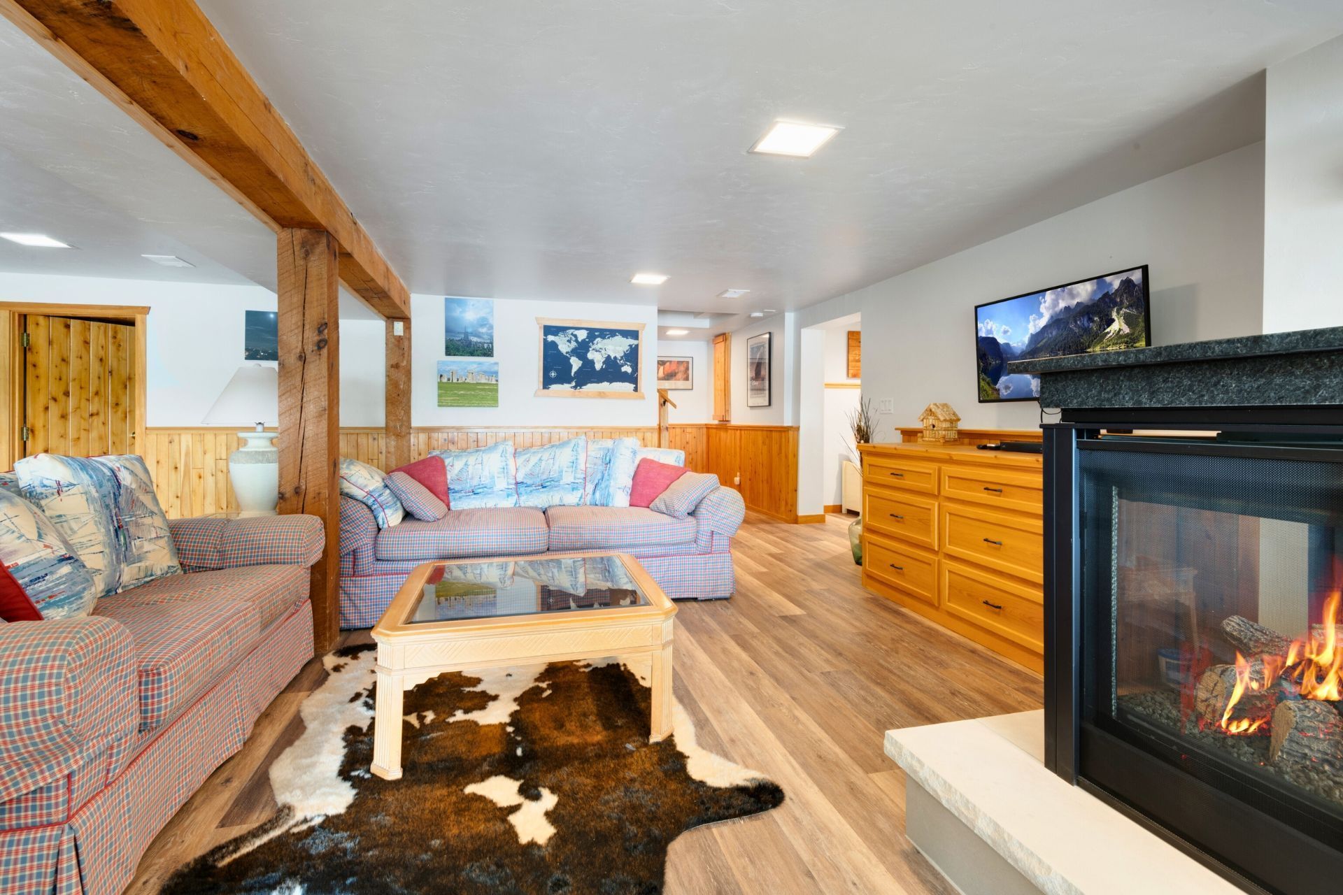 A living room with a fireplace , couch , coffee table and television.