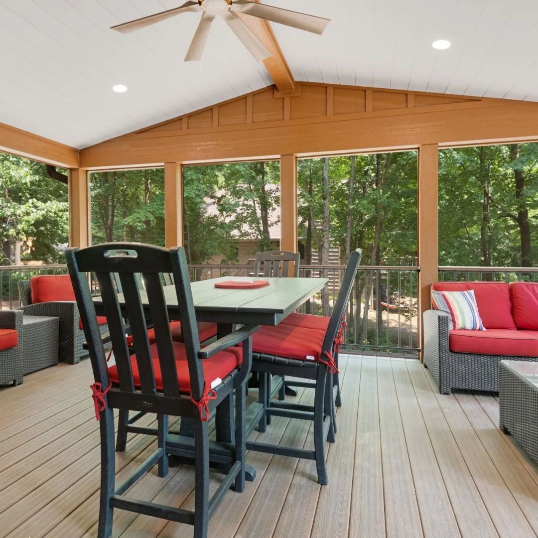 A screened in porch with a table and chairs