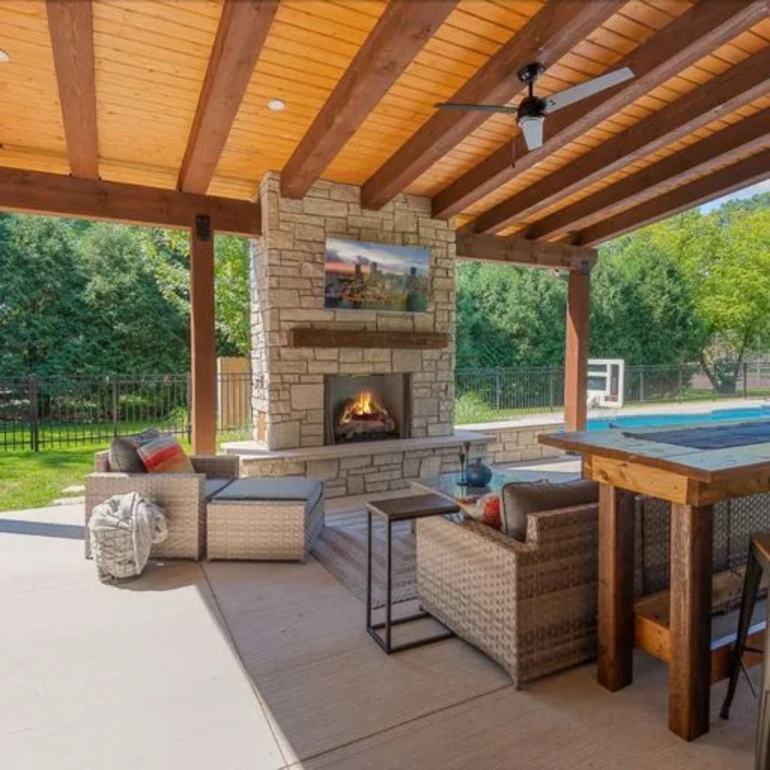 A patio with a fireplace and a ceiling fan