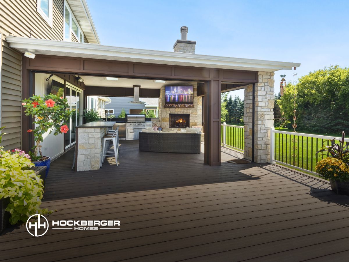 A house with a covered patio with a fireplace and television