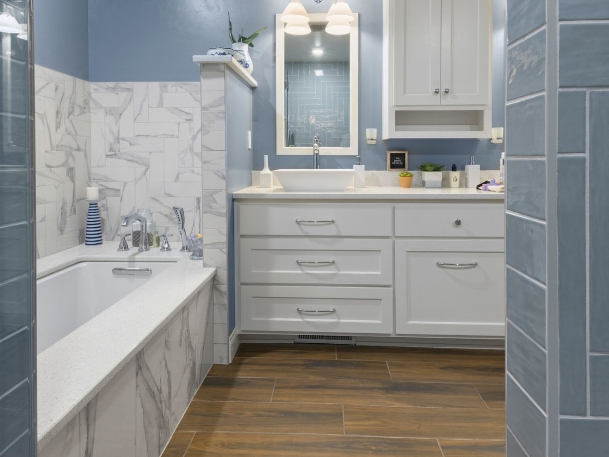 A bathroom with a bathtub , sink and mirror.