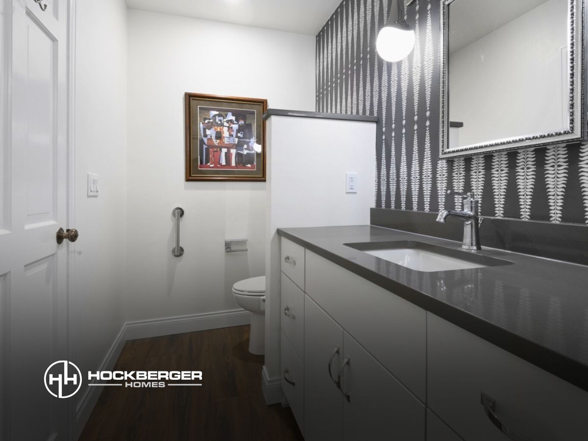 A bathroom with a sink a toilet and a picture on the wall