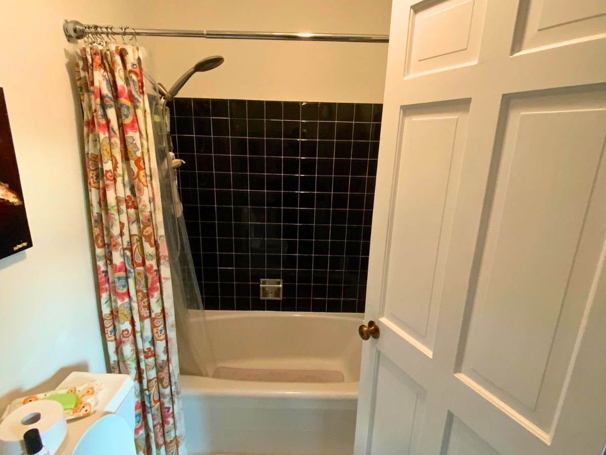 A bathroom with a bathtub and a shower curtain