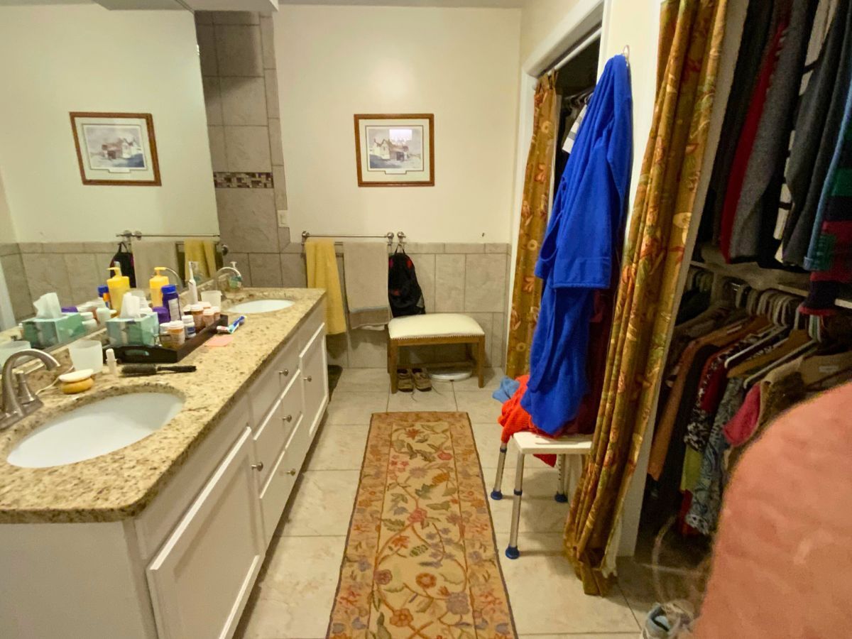 A bathroom with two sinks and a walk in closet