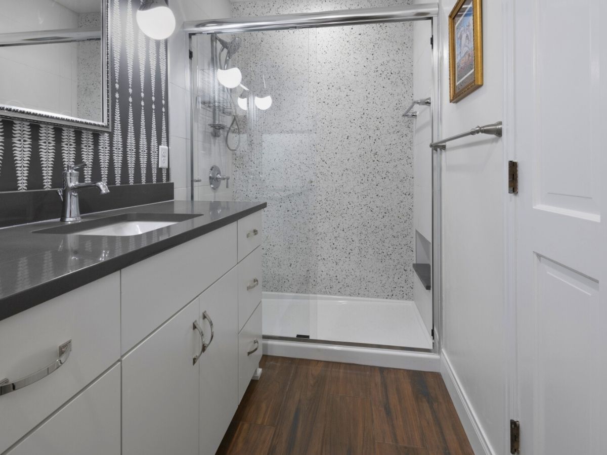 A bathroom with a sink and a walk in shower