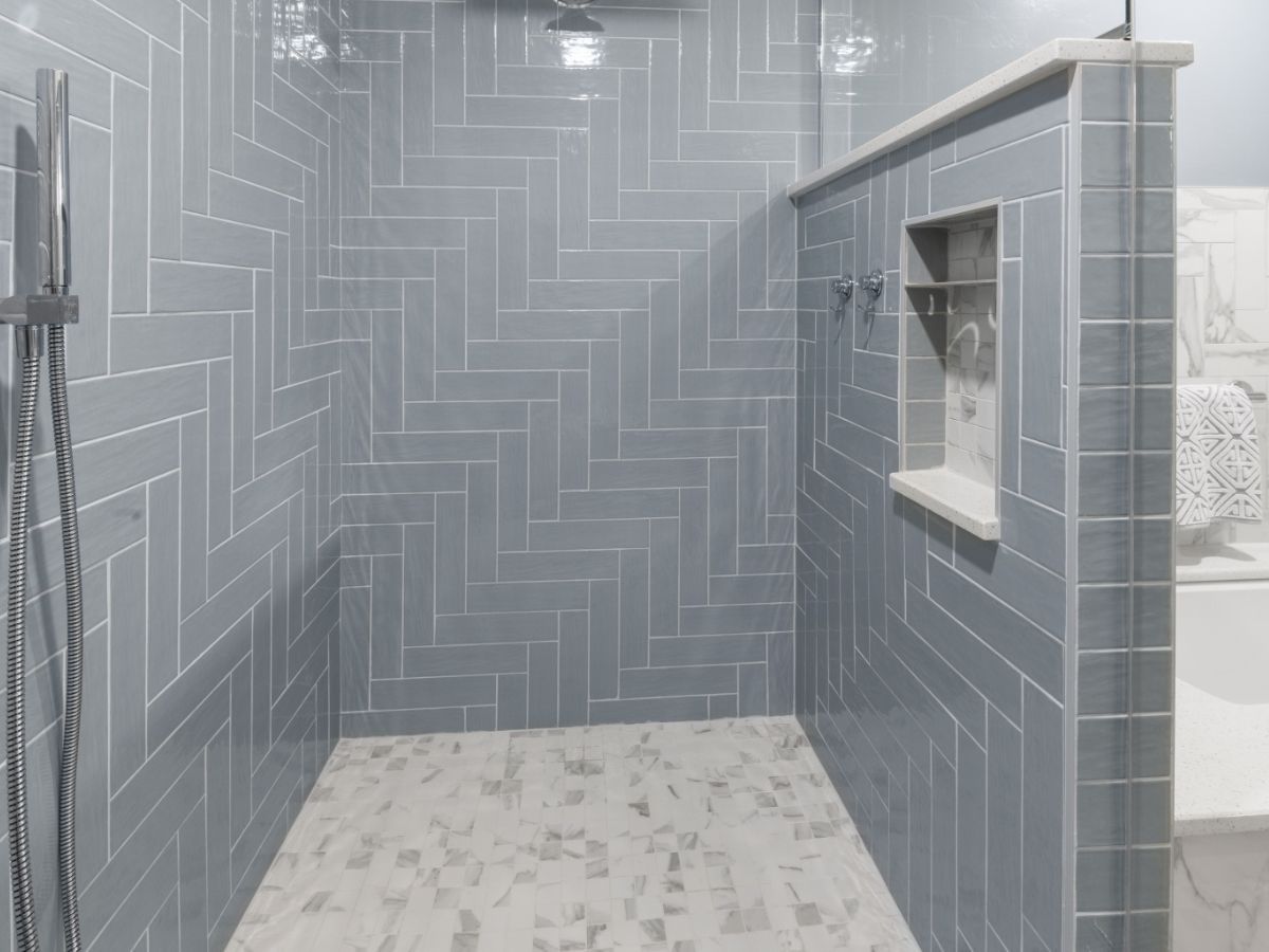 A bathroom with a walk in shower and a sink.