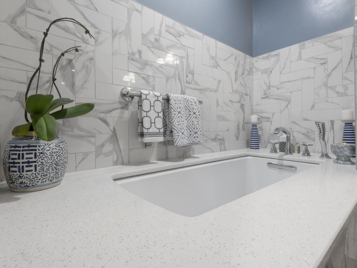 A bathroom with a sink and a vase of flowers on the counter.