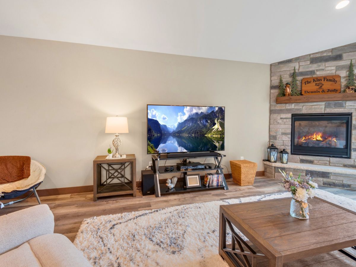 A living room with a fireplace and a flat screen tv.