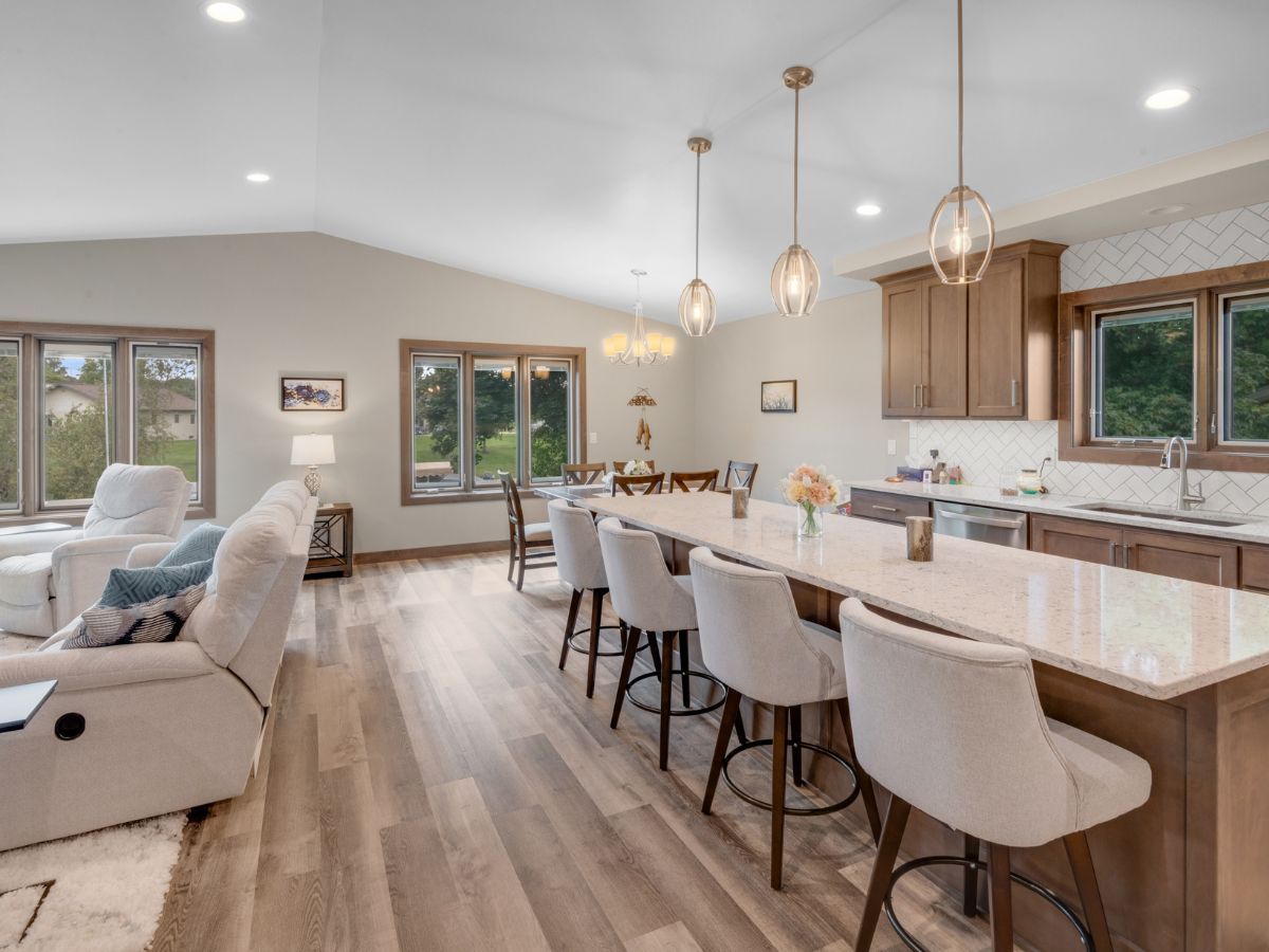 A living room and kitchen in a house with hardwood floors.