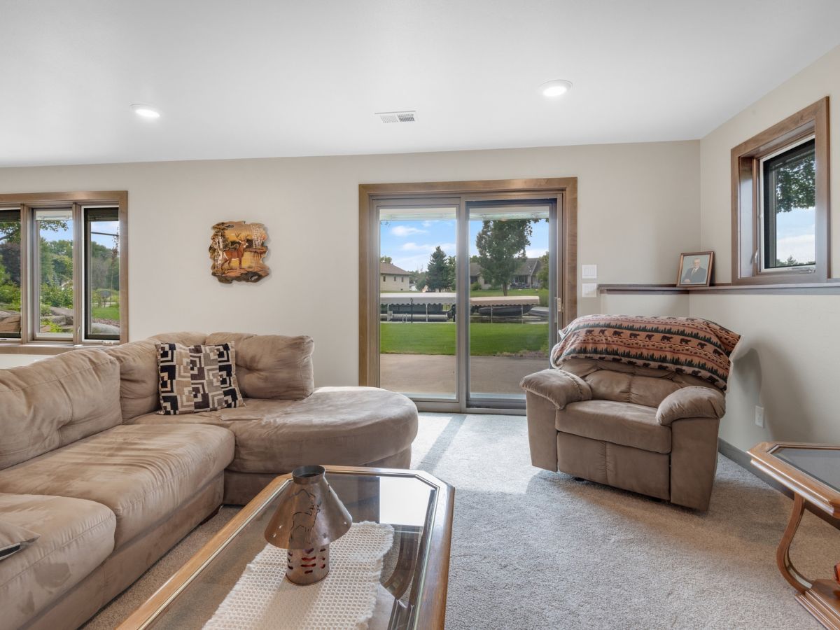 A living room with a couch , chair , coffee table and sliding glass doors.