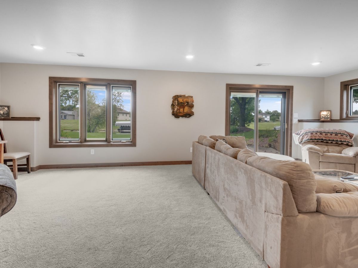 A living room with a couch , chairs , and sliding glass doors.