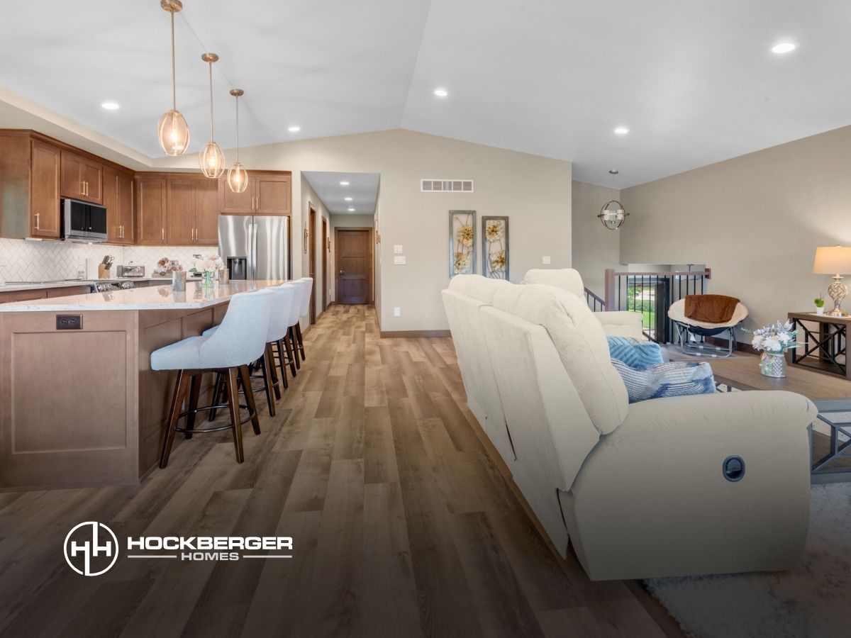 A living room with a couch and a kitchen in the background.