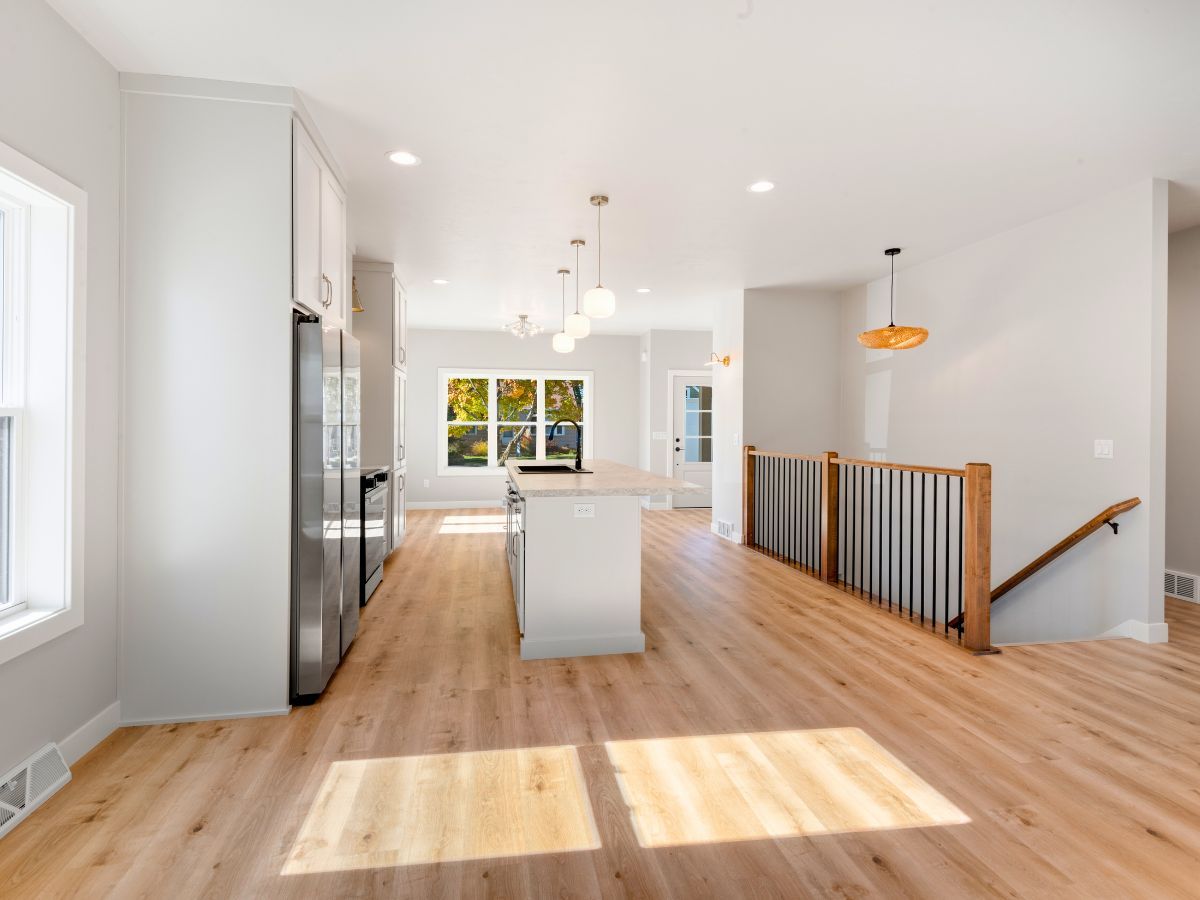 A kitchen with hardwood floors and white cabinets