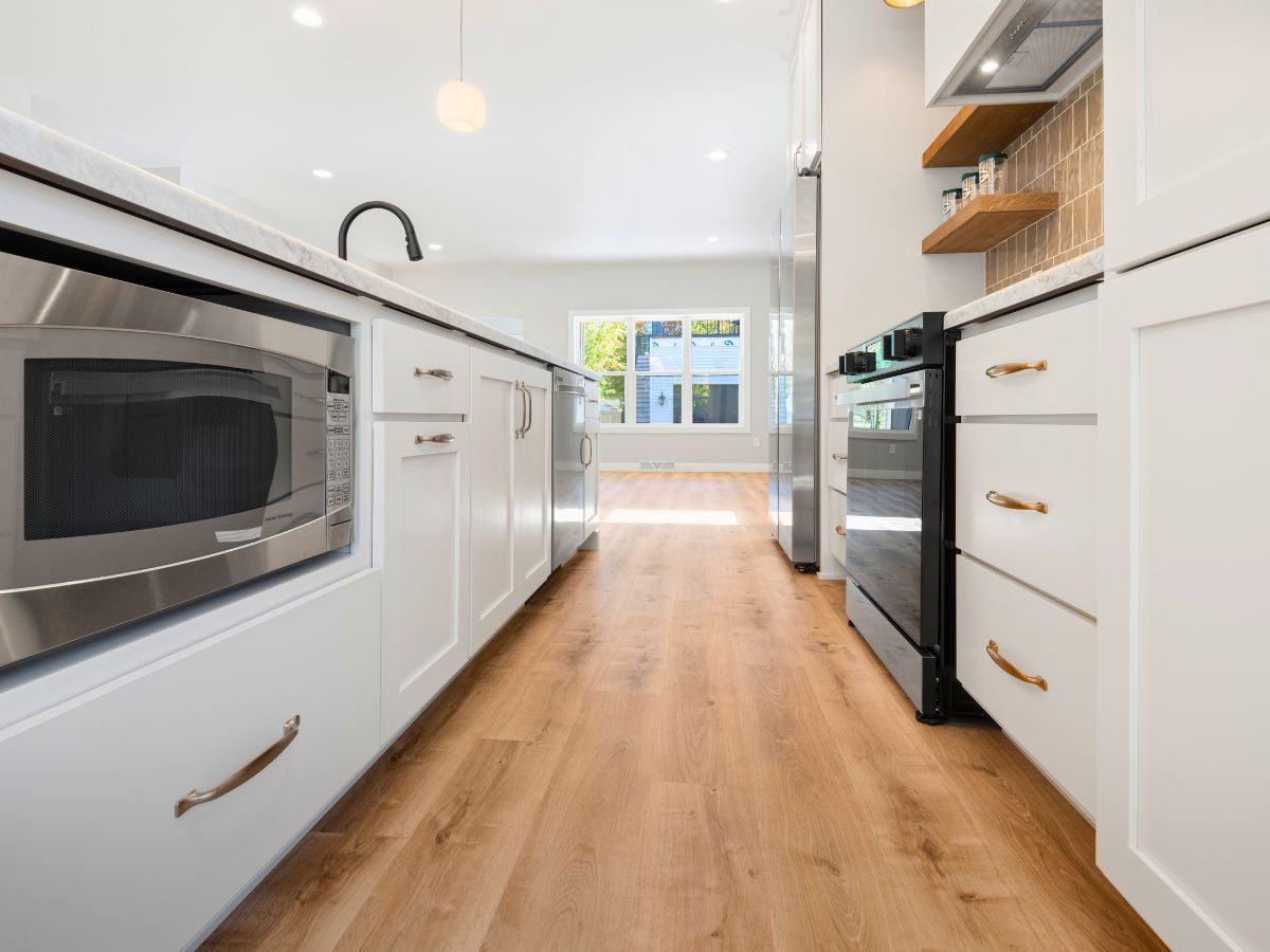 A kitchen with white cabinets and stainless steel appliances