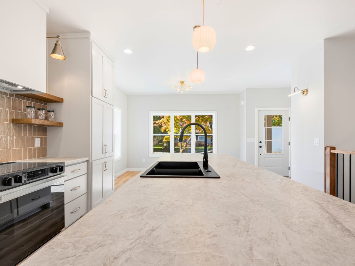 A kitchen with a large island and a sink.