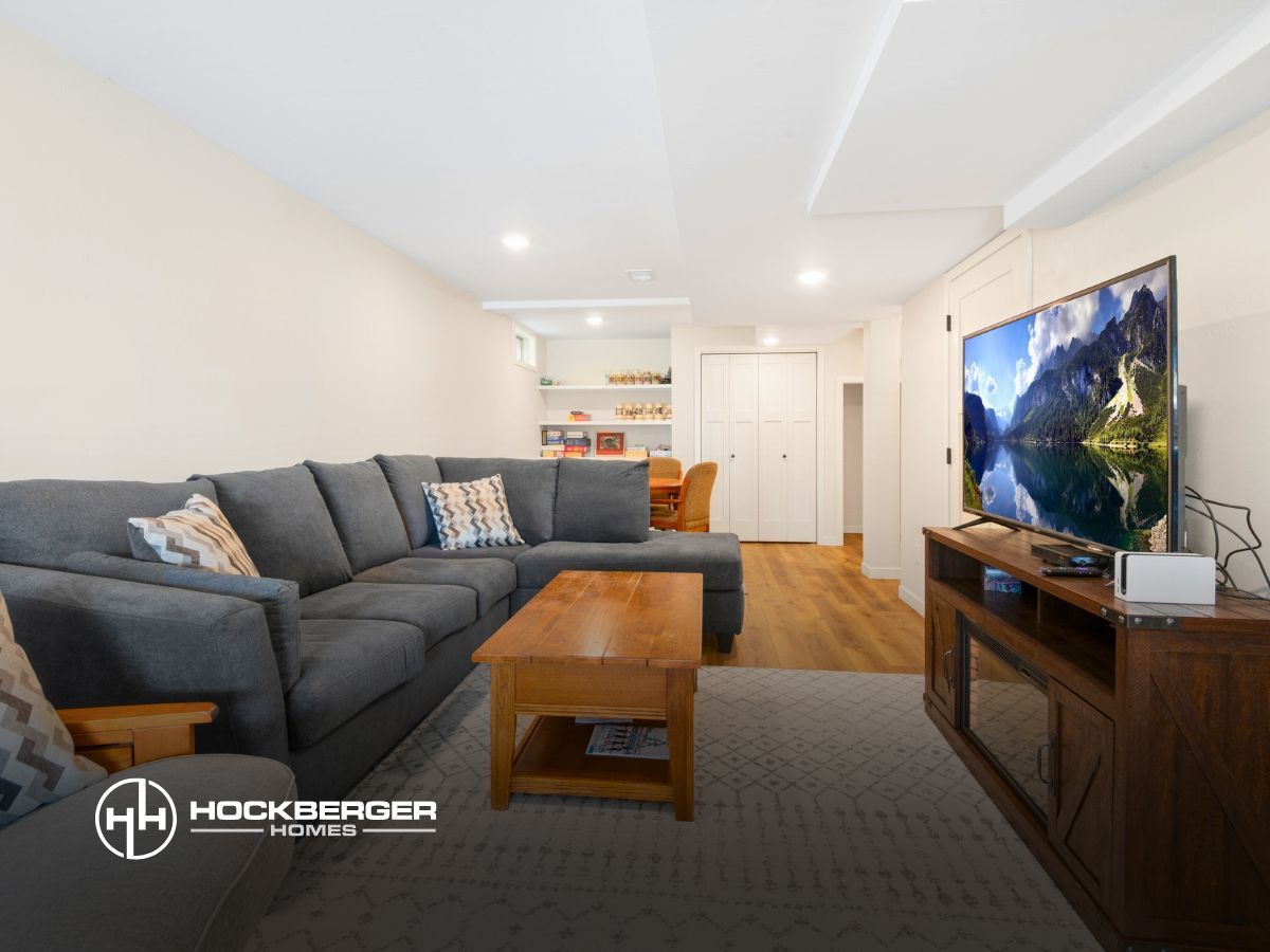 A living room with a large sectional couch and a flat screen tv