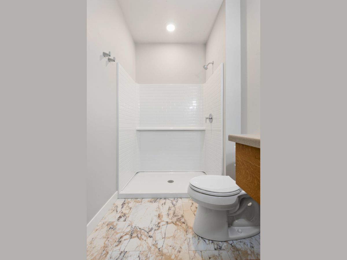 A bathroom with a toilet and a shower stall.