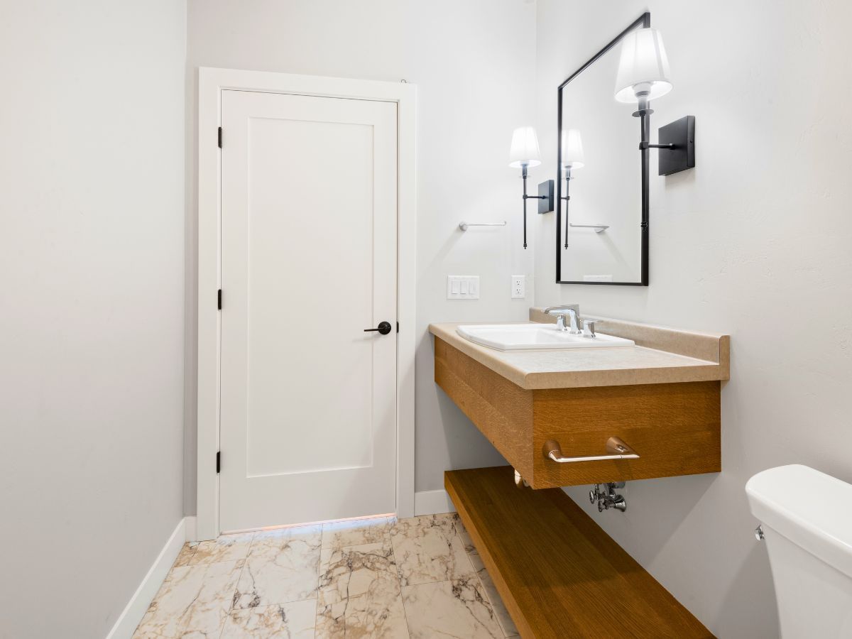 A bathroom with a sink , toilet and mirror.