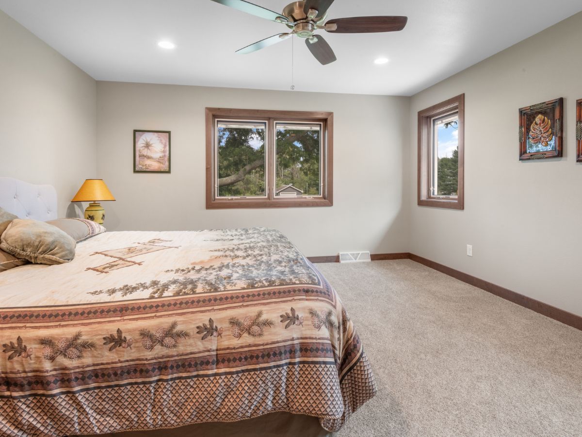 A bedroom with a large bed and a ceiling fan