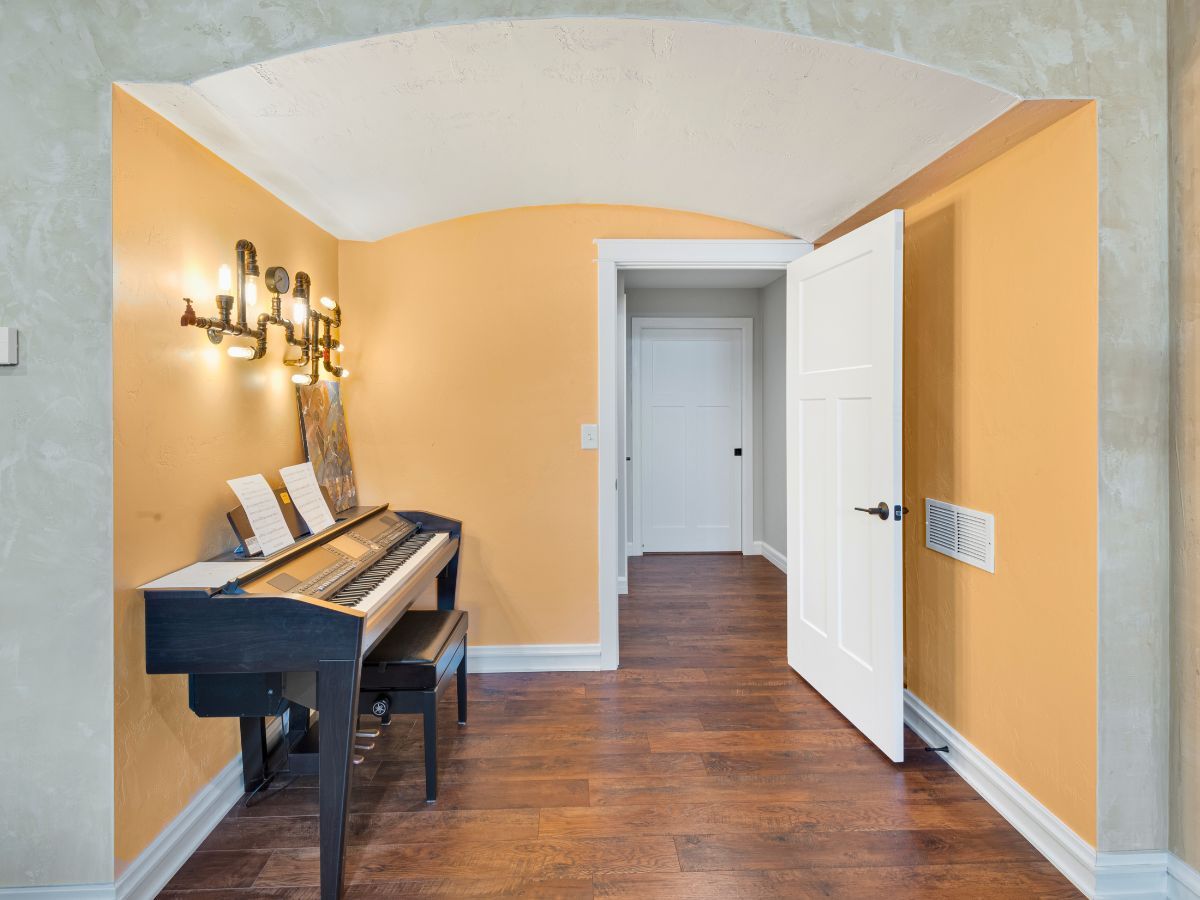 A piano is sitting in a room with yellow walls.