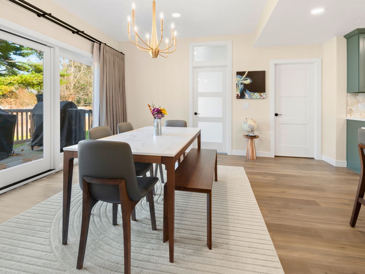 A dining room with a table and chairs and a bench.
