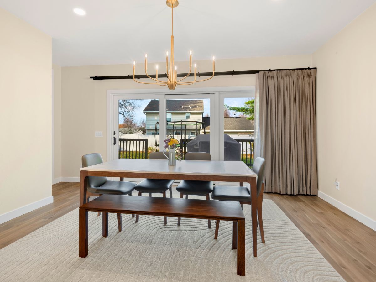 A dining room with a table and chairs and a chandelier