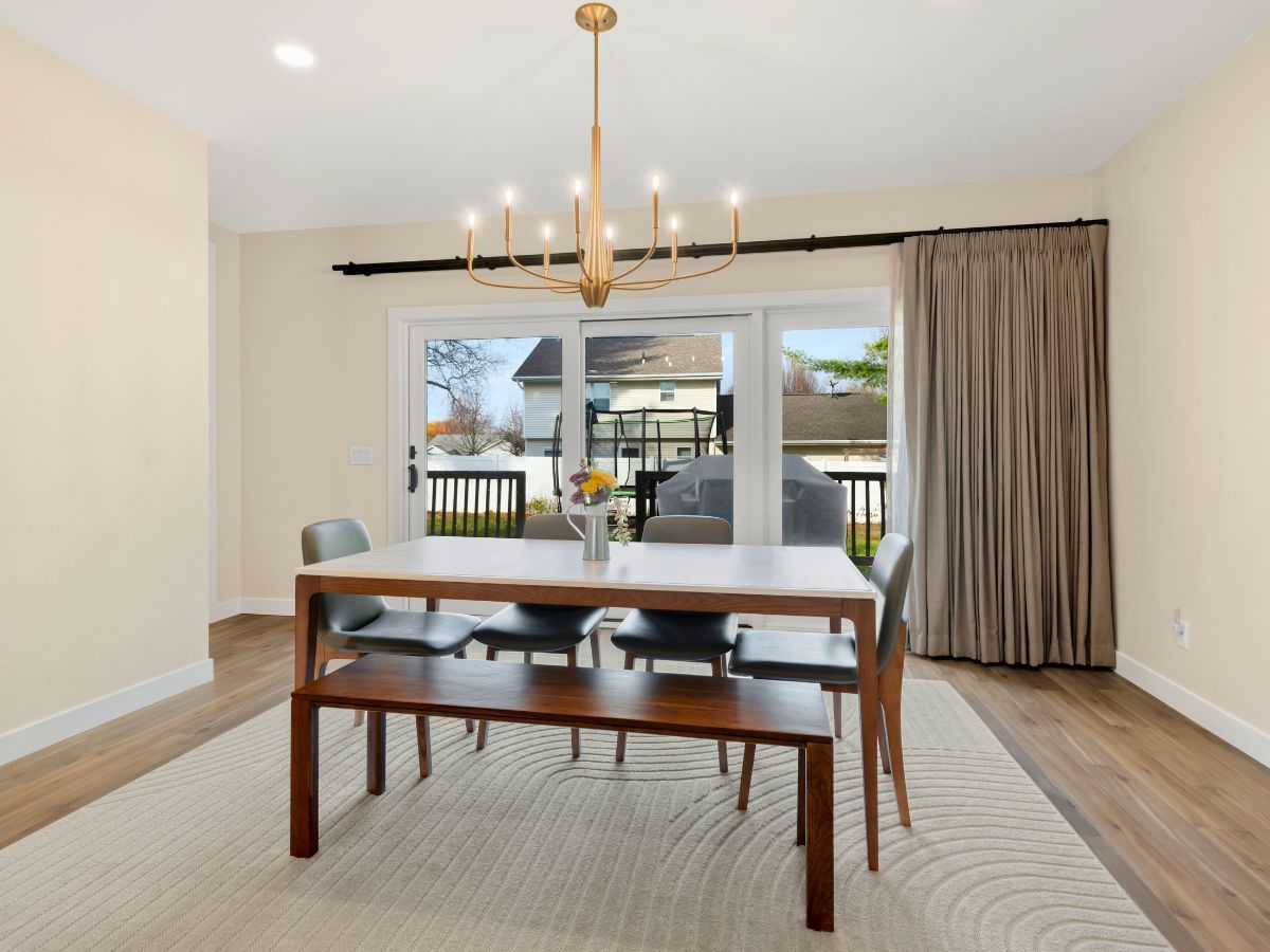A dining room with a table and chairs and a chandelier