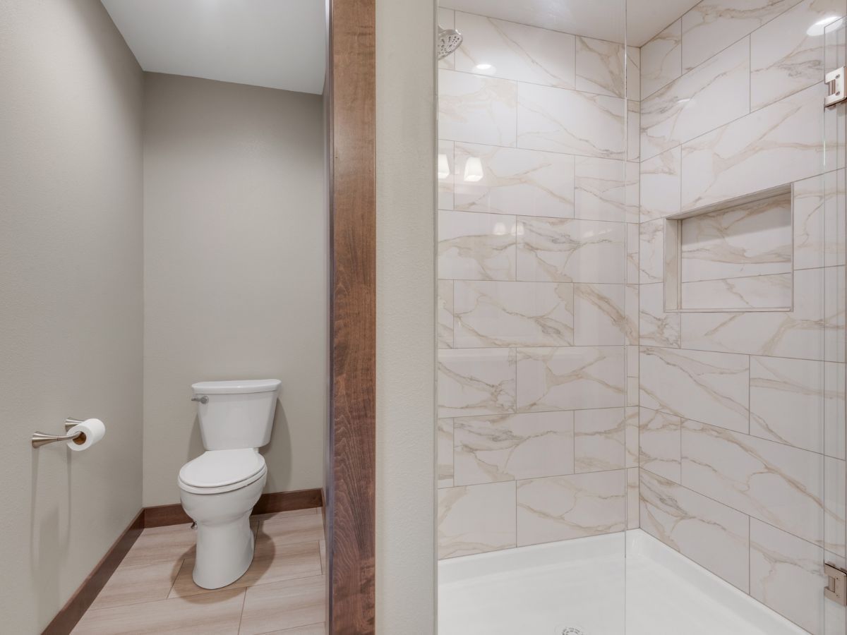 A bathroom with a toilet and a walk in shower