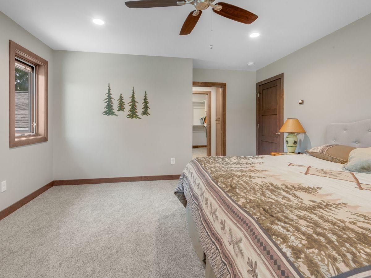 A bedroom with a large bed and a ceiling fan