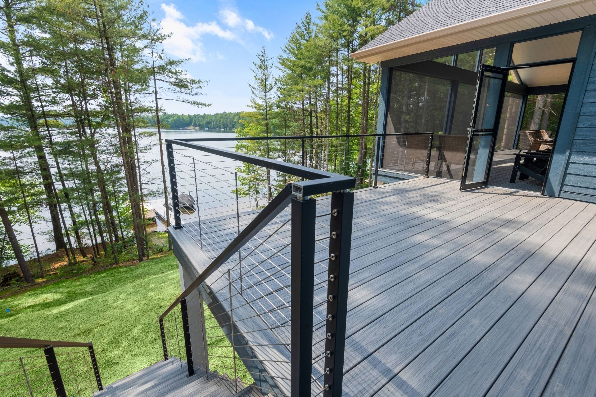A deck with stairs leading up to it and a view of a lake.
