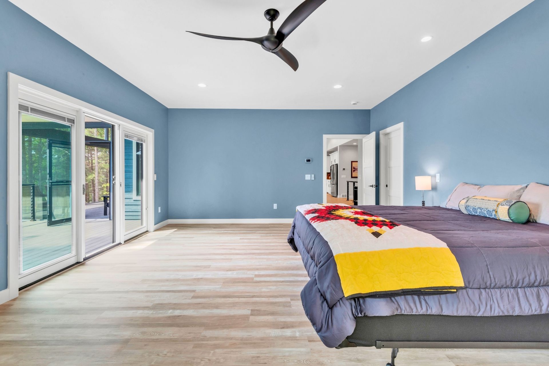 A bedroom with a large bed and a ceiling fan.