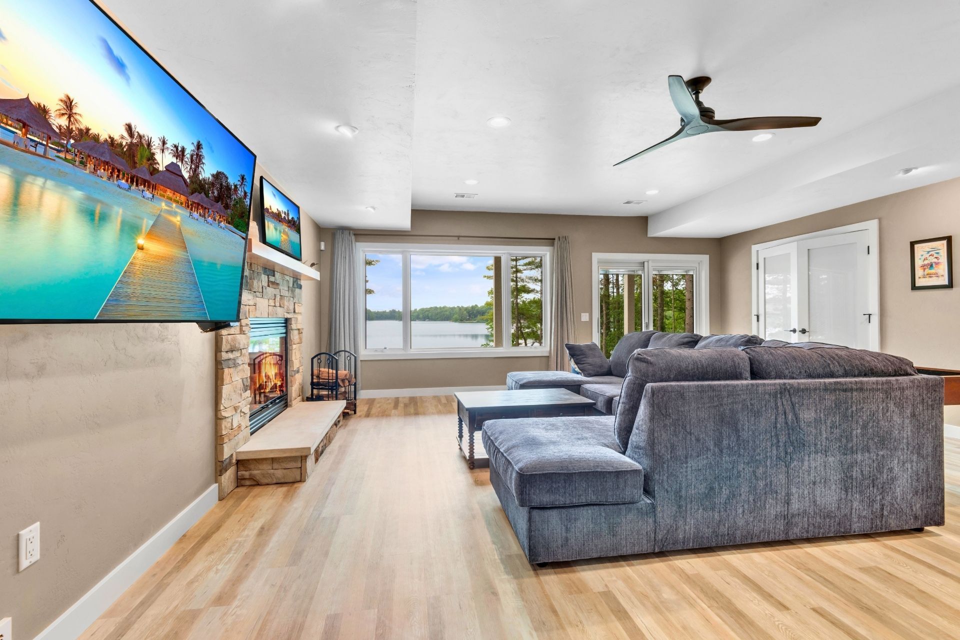 A living room with a couch , fireplace , television and ceiling fan.