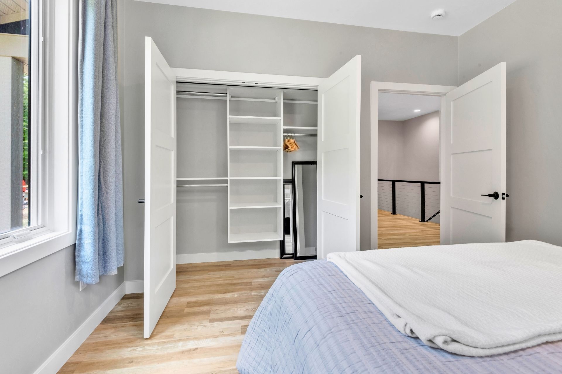 A bedroom with a bed , closet , and window.