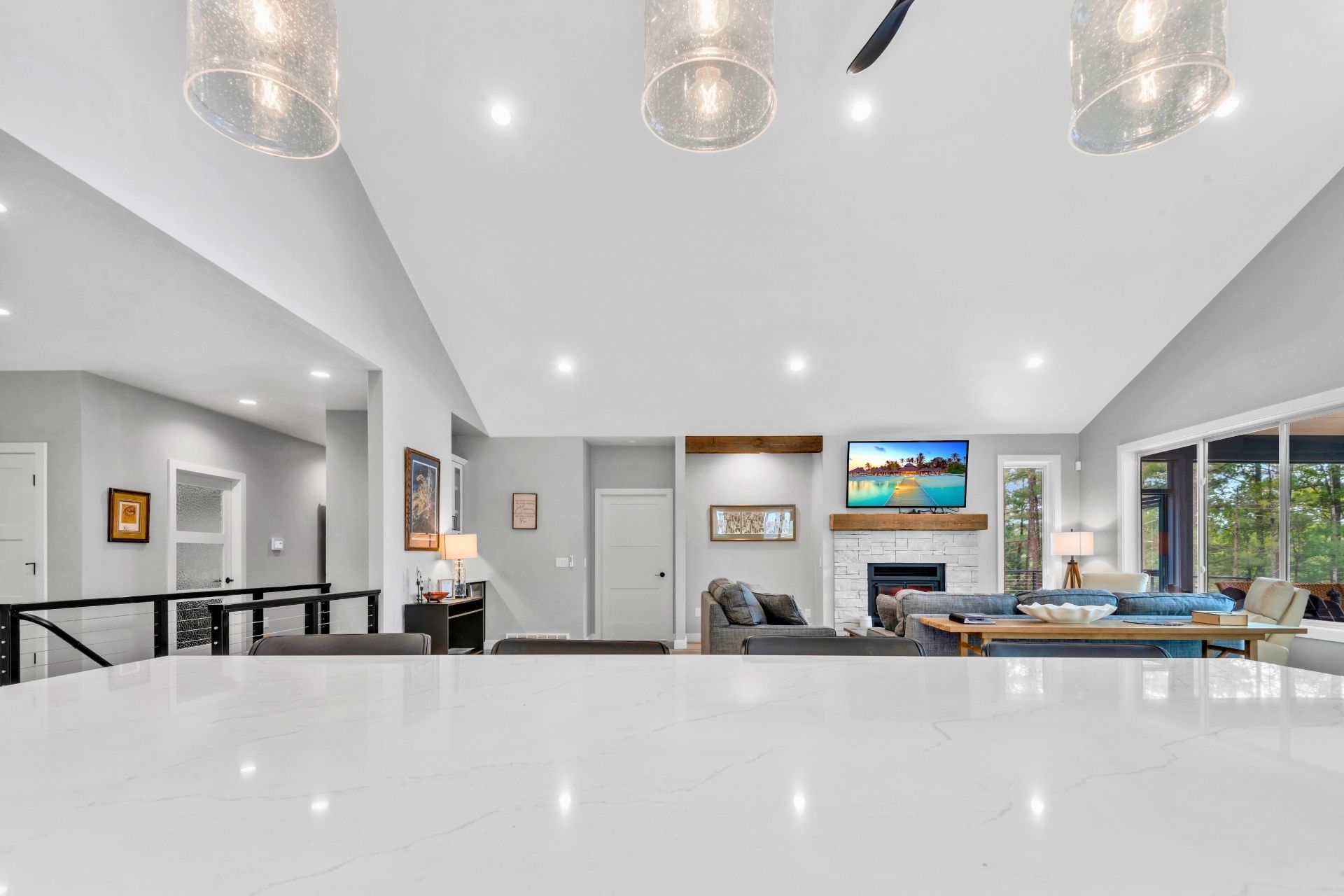 A large living room with a white counter top and a fireplace.