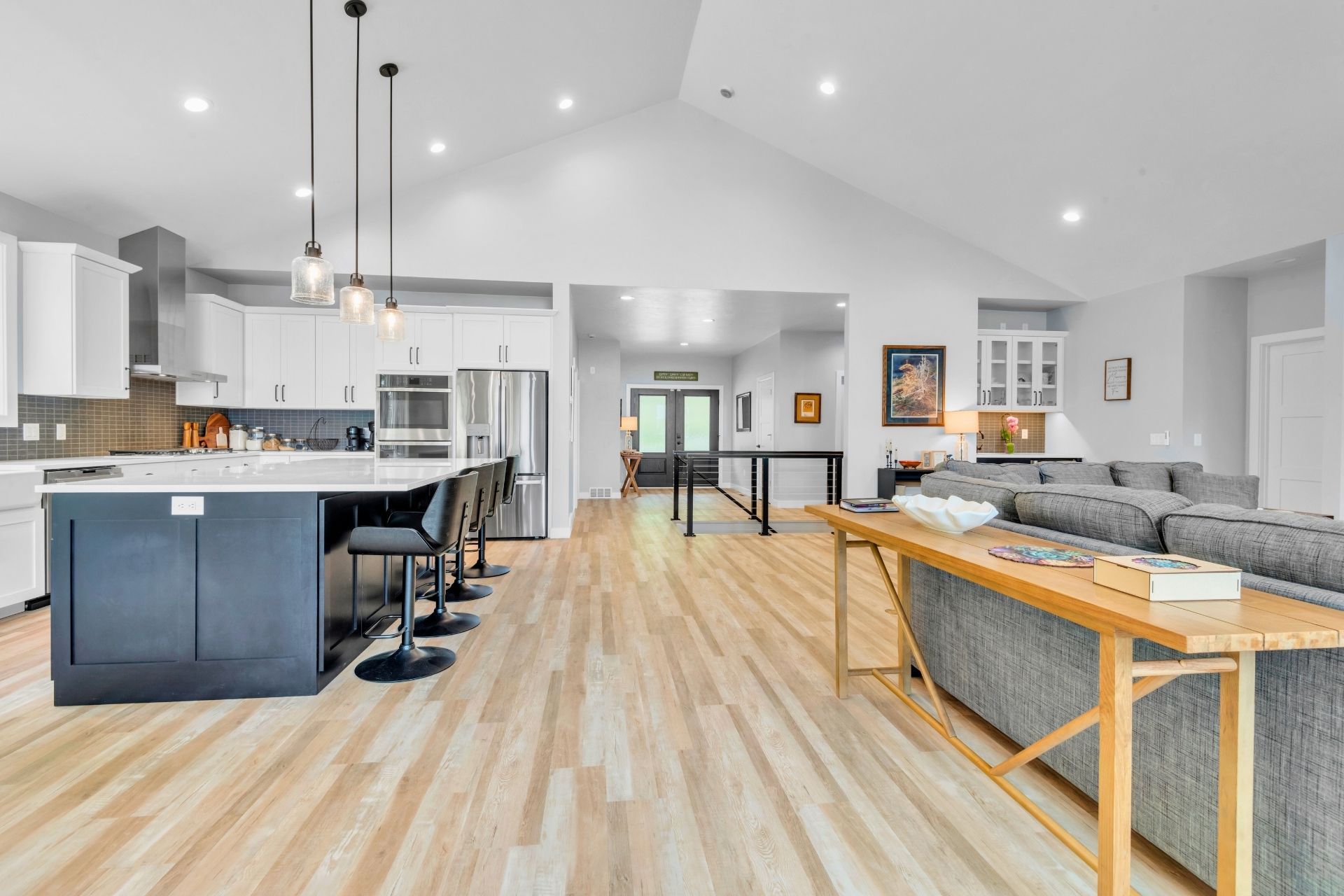 A kitchen , living room , and dining room in a house with hardwood floors.