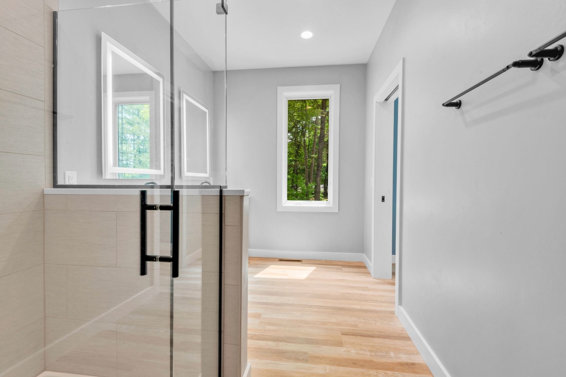 A bathroom with a walk in shower and a window.