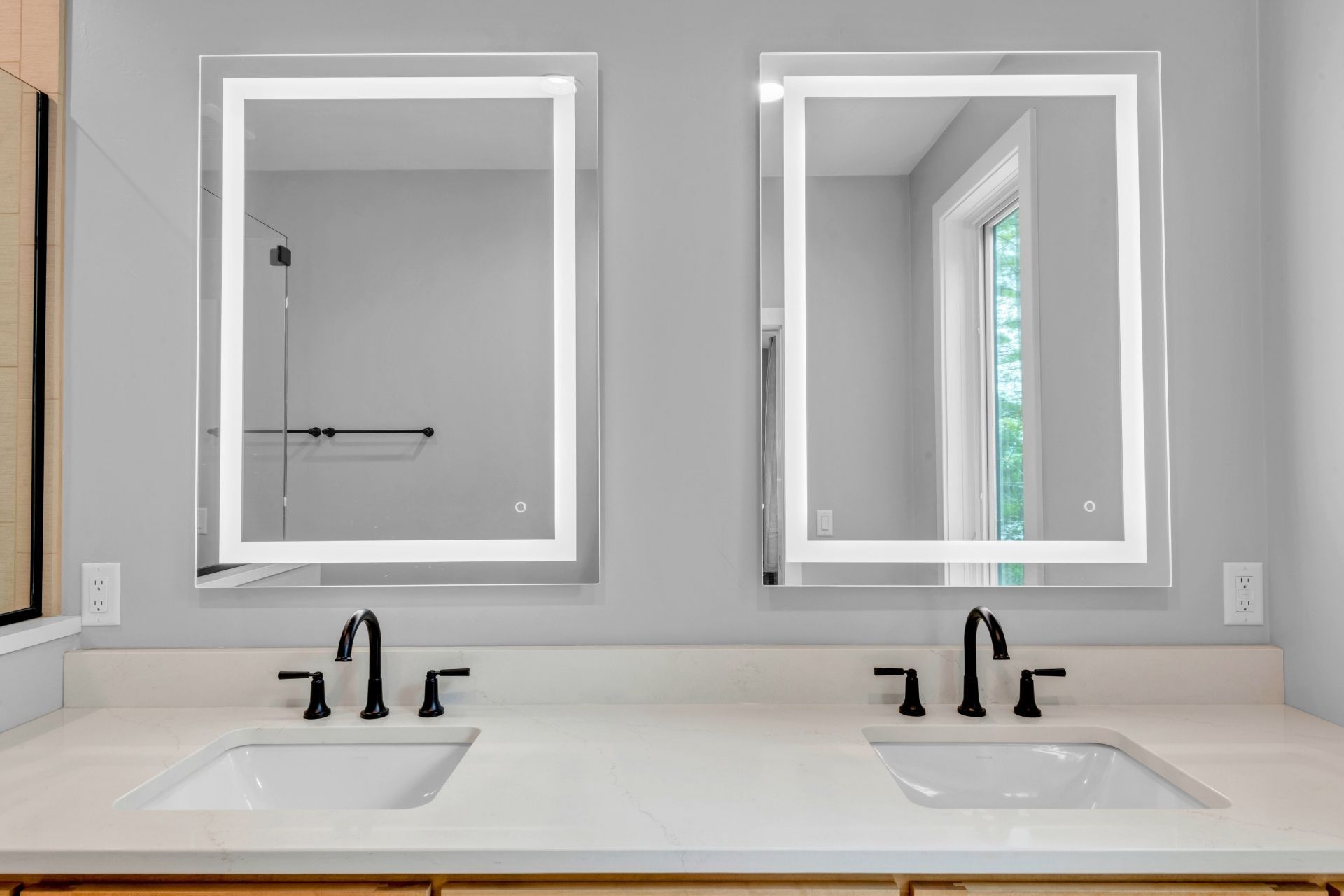 A bathroom with two sinks and two mirrors.